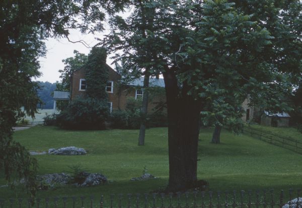 View across lawn toward the brick manor house at Walnut Grove.