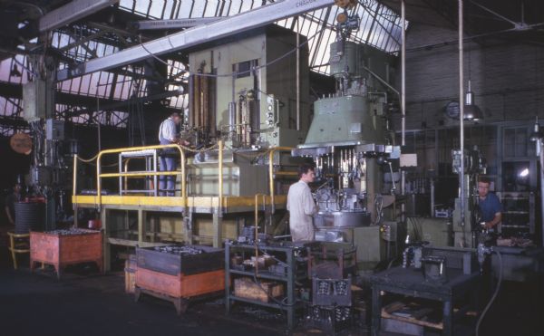 Men working with machinery at factory.