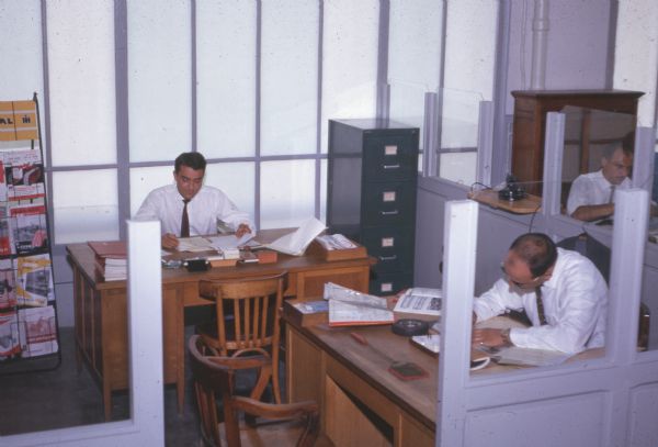 Men working in office cubicles in office.