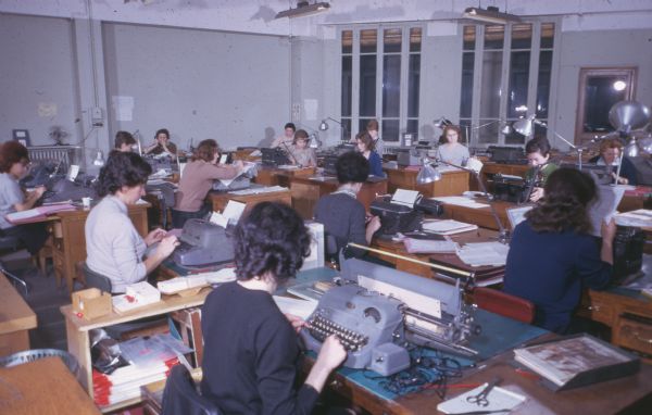 A large group of women are working at desks in an office.