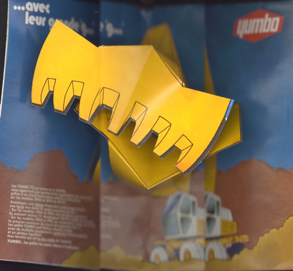 Inside of a brochure advertising Yumbo equipment. There an illustration of an excavator with a pop-up depicting the shovel. Text at top left reads: "...avec leur grande 'g...'"