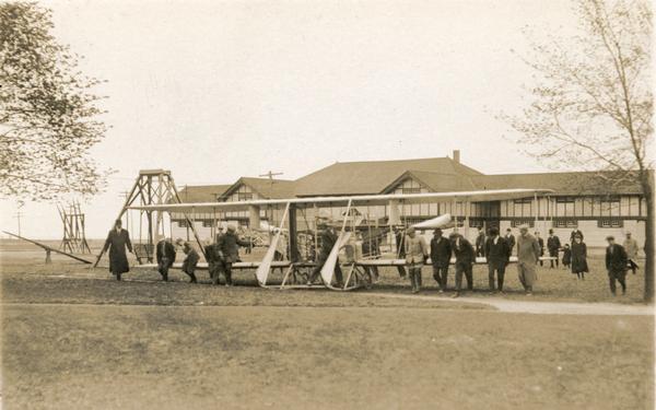The Wright Flyer of Farnum Fish being pushed into position for a demonstration flight at the Wisconsin State Fairgrounds.
