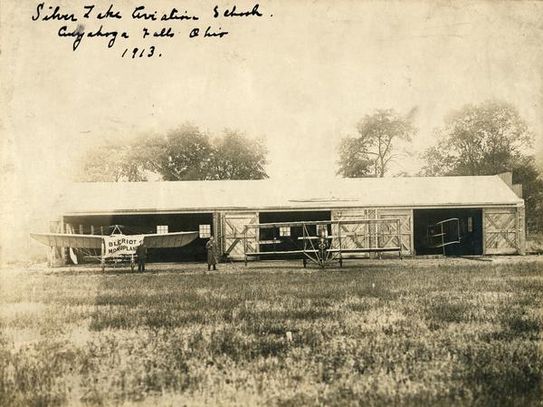 Hangar of the Ohio aviation school of Dr. Rudolph Silverston, formerly of Milwaukee, together with three planes: two Curtiss pushers and a Bleriot monoplane. Flying instructor John Kaminski is thought to be the man in the duster.