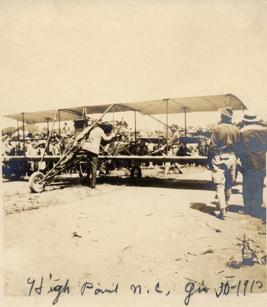 Exhibition pilot John Kaminski preparing to take off at High Point. Here Kaminski is waiting for the engine to warm up; once it is ready he will signal to his mechanic, Jack Knight, to release the restraint.