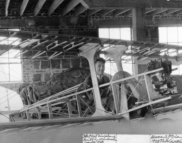 Russell Schuetze of Waukesha with his home built airplane, a single seat Irwin. Schuetze built the airplane (or perhaps some of the airplane) in his father's attic. The original motorcycle engine seen here proved insufficiently powerful, and it was replaced.