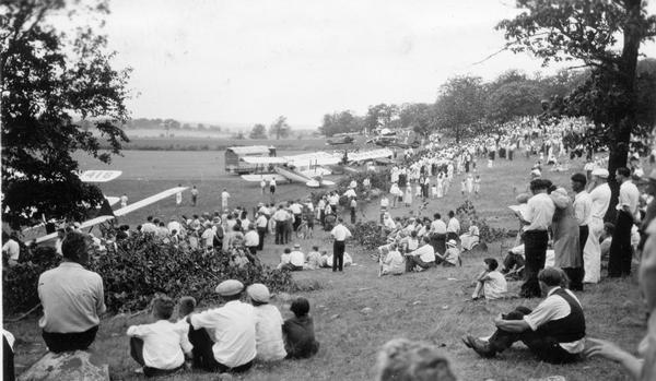 The crowd at a free air show sponsored by the recently organized Waukesha Aviation Club in order to dedicate their new airport. In actuality, the club's airport was little more than a field on the outskirts of Waukesha leased from a local farmer. The air show included races and aerial acrobatics.