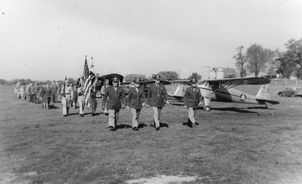 Parade drill of the Waukesha County unit of the Civil Air Patrol. Because World War II ended general aviation, male and female pilots who were either too old or too young for active duty often volunteered for the Civil Air Patrol. It was a way to continue flying while contributing to the war effort. The Waukesha CAP was one of the first units to organize. Their mission was to recruit and train cadets and to carry out search and rescue. The CAP continues as an official civilian auxiliary of the Air Force.