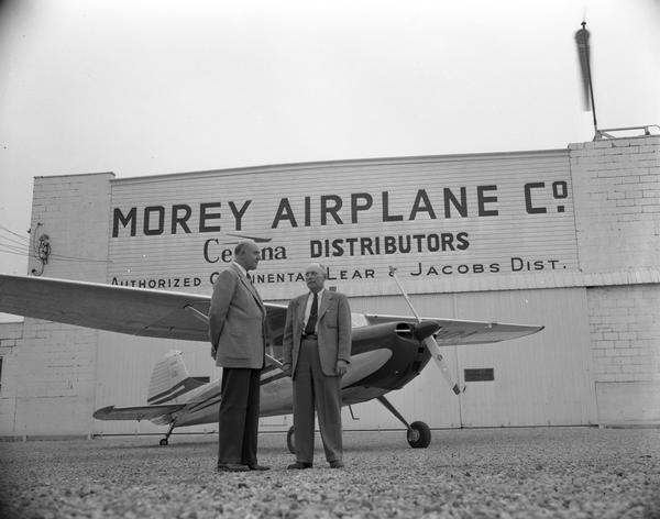 Howard Morey (left) was associated with most of the airports in Madison. Prior to World War II he managed Madison Municipal Airport and when the military took over that field, Morey moved his operations to Middleton. There he established a private airfield, offered flying instructions, and sold planes such as the Cessna on display here. With Morey is Theodore A. Waterman, manager of Morey's Cessna distributorship. More recently, the Morey Airport became the Middleton Municipal Airport.