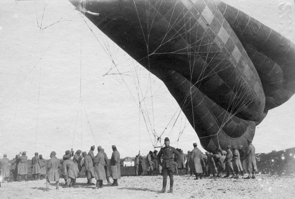 A World War I observation balloon held Gulliver-like by its airship company. During World War I, balloons were positioned near the front so that observers in the gondola could see troop movements and calculate the effectiveness of artillery.