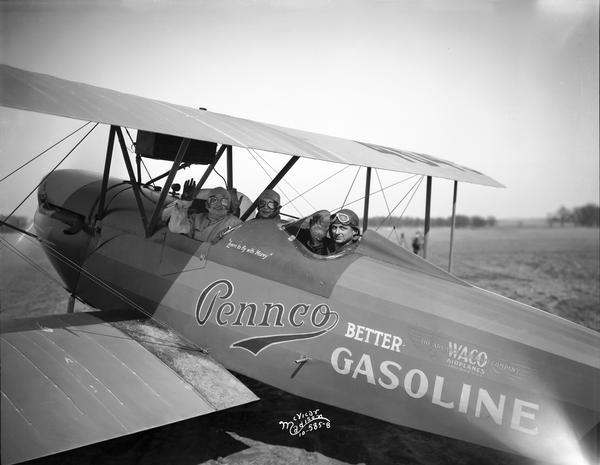 Howard Morey posing in an airplane that advertised Pennco Oil, his distributorship of Waco airplanes, and his flying school. Two women sit in front of him. Painted below his cockpit are the words: 
"Learn to fly with Morey." His diverse operations were typical of most commercial airline operations at the time. Because of the oil company support, Morey's airport was first known as Pennco Field. Later, because of a  partnership with the Royal Transit Co., it became known as Royal Airport. The association with Royal was an unsuccessful attempt to establish a commuter airline between Madison and Chicago.