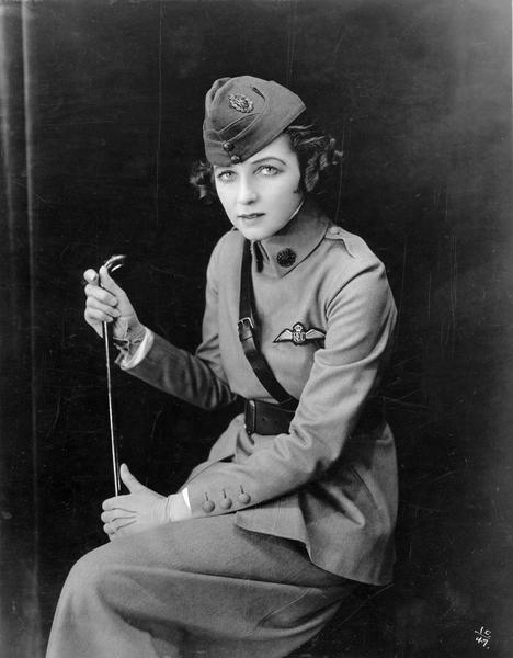 The glamorous dancer Irene Castle wearing a World War I "Preparedness Uniform" of her own design. The dress was based on the uniform worn by her husband and partner, Vernon Castle, an aviator in the Royal Flying Corps. During their heyday, the Castles were the epitome of style and sophistication and Mrs. Castle's wardrobe was frequently copied by society women.