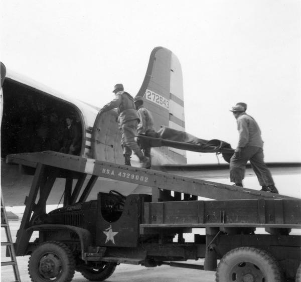 A wounded Korean War soldier being carried on an airplane for evacuation to a military hospital in Japan. This snapshot was taken by journalist and news commentator Cecil Brown. Brown's papers are one of many collections at the Wisconsin Historical Society that concern wartime journalism.
