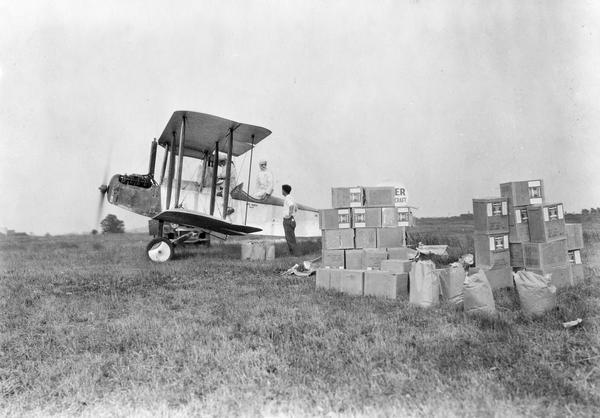 Loading an airplane with calcium arsenate in order to spray for the hemlock looper pest in Peninsula State Park. This is believed to be the first such use of aviation. Little is known about pilot Les Smith whose name appears under the rear seat, but he seems to have lived the rootless life typical of many young pilots during the 1920s and 1930s.  We do know that he flew charters for Midwest Air Transport out of Madison and that he became an airmail pilot with Northwest Airways.  Other photographs of this plane suggest Smith was also associated with the Decatur Aircraft Company in Illinois.