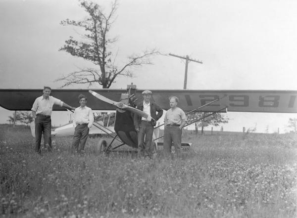 A home built Pietenpol buit by members of the Waukesha Aviation Club after its initial flight. They are Chet Wolt, Jack Leeman, Dean Crites, and Bob Lathrop. Dean Crites, one of two brothers well-known in Wisconsin aviation, had flown the test flight. Their airplane was designed by Bernard Pietpenpol to make aviation affordable for the average citizen. His planes were available as kits, parts, or plans.   