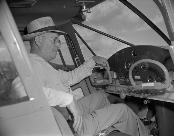 An unidentified pilot seated in the cockpit of a Stinson sport airplane at Richland County Airport. He had flown there to attend the airport dedication.