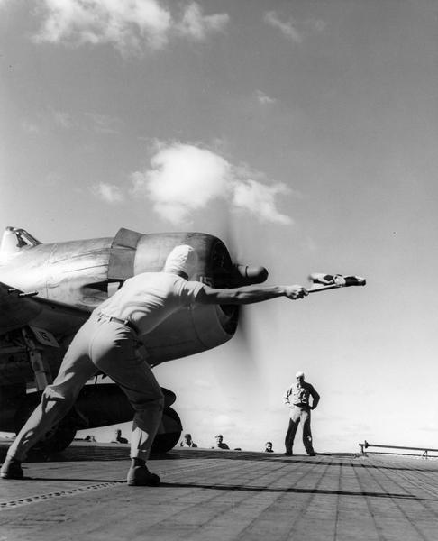 The launching office above a Pacific Fleet aircraft carrier gives the "go" signal to the pilot. This photograph is from a scrapbook compiled by Philip F. La Follette, former governor of Wisconsin and press aide to General Douglas MacArthur during World War II, from official releases that crossed his desk.