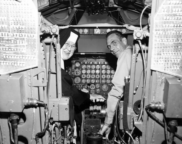 The real flying nun, Sister Mary Aquinas Kinskey, O.S.F., in a B-52 simulator with Major Ralph M. Hanson. Sister Mary Aquinas was fulfilling her dream of flying a jet plane. The sister, whose Franciscan motherhouse was in Manitowoc, Wisconsin, learned to fly during World War II in order to teach her students. Later she was involved with pre-flight instruction for the military, and after the war she continued to fly. Sister Mary Aquinas introduced aviation into the science curriculum of various schools in Wisconsin and elsewhere.