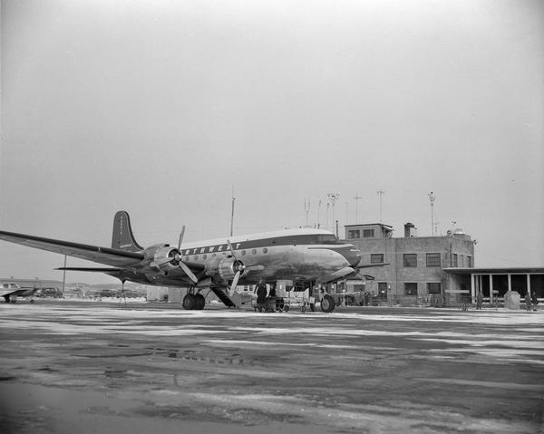 A Northwest Airlines DC-4 plane at the Truax terminal. Originally constructed in 1937 with assistance from the WPA, the Madison Municipal Airport was renamed Truax Field during World War II to honor Tommy Truax, a local air cadet killed during a training accident.