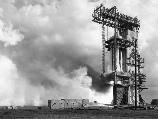 A Saturn C-1 booster rocket (later renamed Saturn 1) during a static firing at the Marshall Space Flight Center. This test was an early stage in the development of the Saturn V. The photograph is part of the NASA press material collected by journalist Robert Goralski whose papers are housed in the Wisconsin Historical Society Archives.