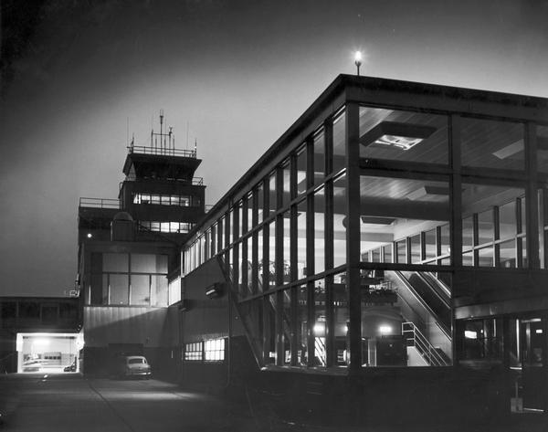 Control tower and entrance to the new Howell Street passenger terminal at General Mitchell Field shortly before its formal opening in July 1955. The Milwaukee airport, originally known as Milwaukee County Airport, was renamed in 1941 to honor General Billy Mitchell who grew up in Milwaukee. In 1955, the year in which this photograph was taken, Mitchell Field handled an estimated 500,000 passengers. In 1986, the airport was renamed General Mitchell International Airport.