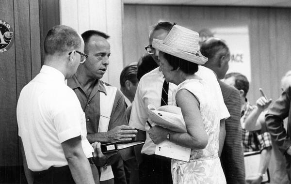 Astronaut Alan Shepard (second from the left), then the head of NASA's astronaut office, talks with the press at Cape Canaveral before the Gemini 8. On April 14, 1961, Shepard became the first American to travel in space. His flight, which was broadcast to a nervous nation, was sub-orbital, and it lasted only 15 minutes--not too much longer than the Wright Brothers' longest flight in 1903. Later an inner ear disturbance removed Shepard from flight status, but after surgery he was able to command Apollo 14 and walk on the moon.