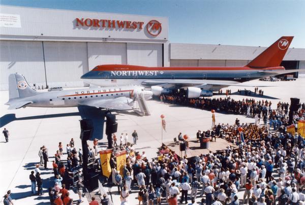 Northwest Airlines celebrated the 50th anniversary of its around-the-globe service to the Orient at Minneapolis Airport in 1997.  For this event the airline displayed a DC-4, the aircraft that originally flew the Orient route, and a 747, the plane that flew the route in 1997.  Ironically, as indicated by the name on the airline hangar, Northwest no longer used the Northwest Orient Airlines name. The Douglas DC-4 was a larger version of the DC-3 that was successful as a commercial airplane and as the C-54 transport during World War II and the Berlin Airlift.  The 747 series, which was introduced by Boeing in 1970, was then the world's largest passenger airplane.   The promotional campaign for this anniversary was submitted in an award competition of the Public Relations Society of America.  The PRSA records are available for research at the Wisconsin Historical Society Archives.
