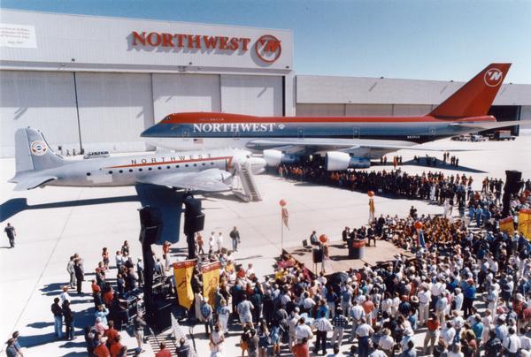 Northwest Airlines celebrated the 50th anniversary of its around-the-globe service to the Orient at Minneapolis Airport in 1997.  For this event the airline displayed a DC-4, the aircraft that originally flew the Orient route, and a 747, the plane that flew the route in 1997.  Ironically, as indicated by the name on the airline hangar, Northwest no longer used the Northwest Orient Airlines name.
The Douglas DC-4 was a larger version of the DC-3 that was successful as a commercial airplane and as the C-54 transport during World War II and the Berlin Airlift.  The 747 series, which was introduced by Boeing in 1970, was then the world's largest passenger airplane.  
The promotional campaign for this anniversary was submitted in an award competition of the Public Relations Society of America.  The PRSA records are available for research at the Wisconsin Historical Society Archives.