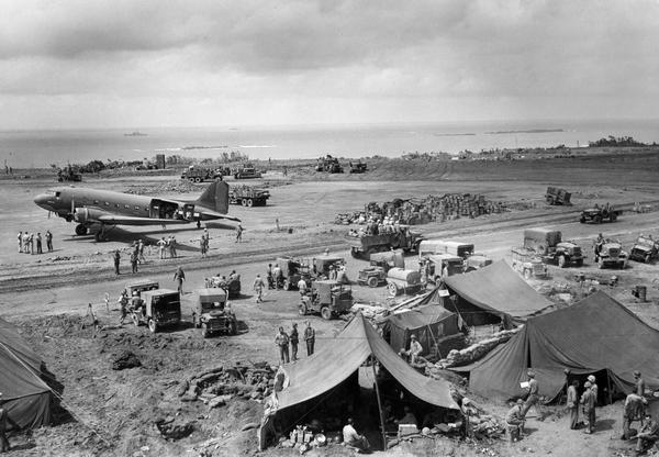 Iwo Jima Airfield #1, as it appeared nine days after the initial assault.  On the runway is a C-47 transport plane, the military equivalent of the DC-3.  This image is one of many of the long battle for Iwo Jima taken by Milwaukee photographer Dickey Chapelle.