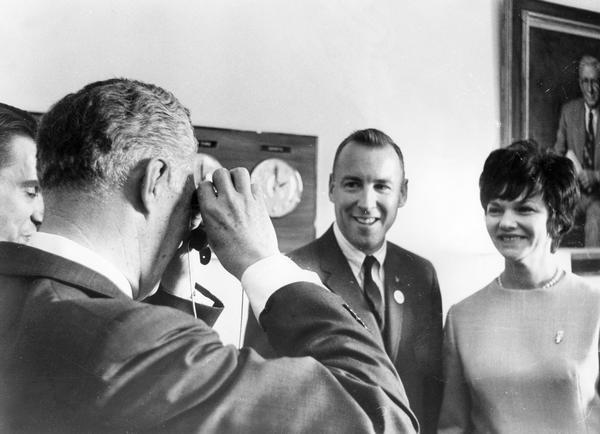 Astronaut James A. Lovell and his wife during a visit to Wisconsin. One measure of Lovell's celebrity status is the fact that it is Wisconsin's  governor, Warren P. Knowles, who is snapping the photograph.  At the time Lovell had already completed successful flights on Gemini 7 and 12.
