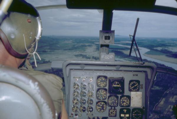 Helicopter cockpit showing the pilot's view of the Vietnamese Delta region below. This photograph was taken by Milwaukee freelance photographer Dickey Chapelle.