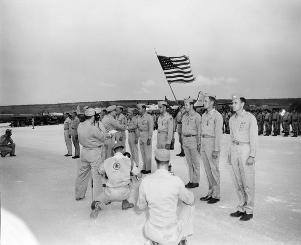 The medal ceremony for the crew of the <i>Enola Gay</i>, the B-29 Super Fortress that dropped the atomic bomb on Hiroshima. This photograph was taken by Alan North Williams, a photographer's mate in the Navy.  While the majority of the photographs in Williams' collection are official, it is possible this photograph by Williams was not.