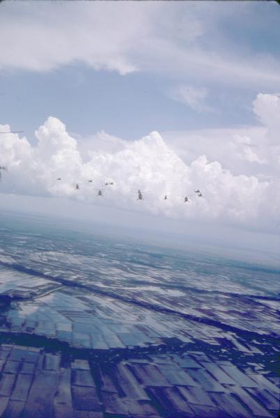 Distant view of U.S helicopters over the Delta Region of South Vietnam taken by Dickey Chapelle, a freelance photographer from Milwaukee.