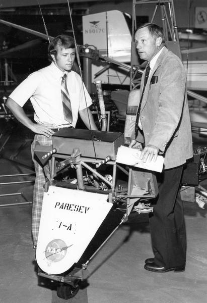 Astronaut Neil Armstrong (right), the first man to walk on the surface of the Moon, with Tom Poberezny, the son of EAA founder Paul Poberezny and the president of the EAA Foundation. Between them is a PARASEV, an experimental paraglider designed to return space capsules to earth.  Armstrong had tested the PARASEV for NASA in 1962.