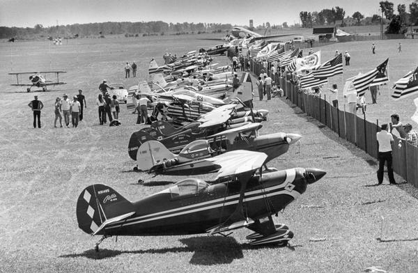 Airplanes entered in the 10th World Acrobatics Championships at Wittman Field in Oshkosh. The planes in the foreground are those of the Australian and Canadian teams. Several Pitts Aerobatic planes can be seen in the line.