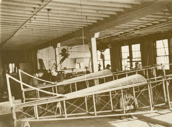 Workers in Carl Bates' airplane factory in Chicago. The history of Bates' various aviation enterprises is sketchy, but it is known that he built airplanes and motors in Chicago until about 1912 when he sold out to the Edward Heath company and that he went into business again on his own during World War I. It is likely that this photograph of fuselage construction dates from that era.
