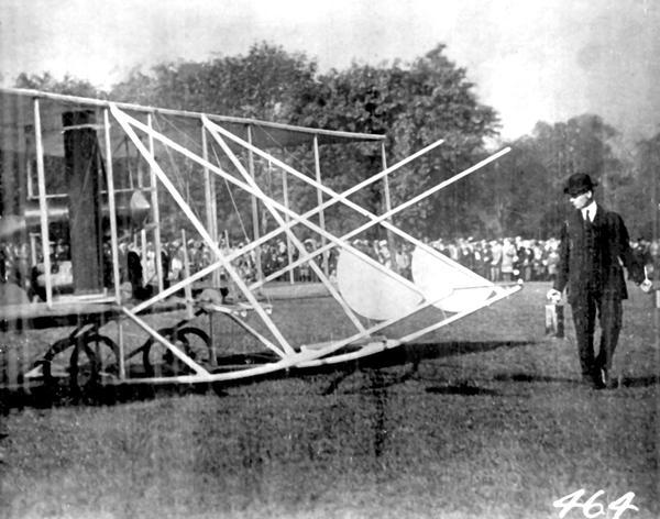 Wilbur Wright, in profile, with a Wright Flyer. The original photographic postcard from which this image was copied was presented by Wright to pioneer aviator Jesse Brabazon of Delavan, Wisconsin. Brabazon recalled that at the time of the Chicago International Aviation Meet in 1912 he had been in correspondence with Wright about the purchase of a new plane. Wilbur looked him up during the Chicago meet and gave him the card.