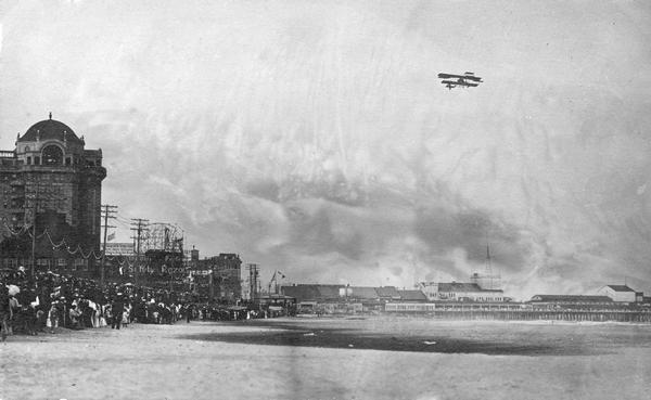 Walter Brookins, a boyhood friend of the Wright Brothers, flying a Wright airplane over the ocean at Atlantic City. Brookins set numerous records for altitude, distance, and endurance. On this day he flew at an altitude of 6,175 feet.