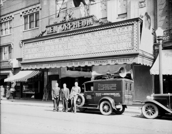 Three men standing beside Powerizer sound systems truck (Radio Laboratories, Inc. Milwaukee) in front of Orpheum Theatre, 216 State Street. "The Laff Riot of this or any other year, The Cuckoos, with comics of Rio Rita, Bert Wheeler & Robert Woolsey & Vodvil."