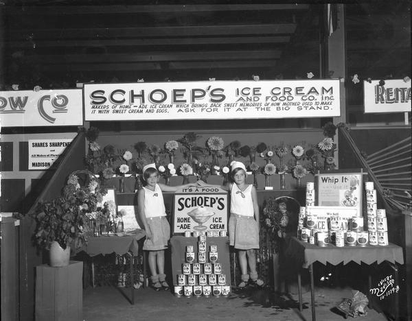 Two girls standing at the Schoep's Ice Cream and Food Company Inc. booth at the ESBMA (East Side Business Men's Association) fall festival.