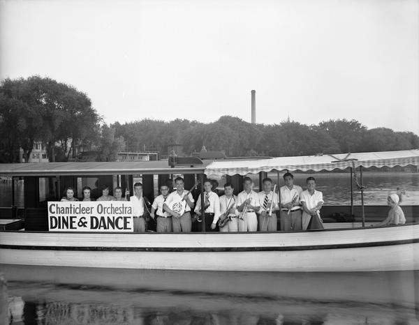 Chanticleer Orchestra, the "Piffles" Jaeger Band with instruments, on lake passenger boat. Band members and guests are: Left to right: Ruth Bourrette, Mrs. Larry Becker, Mrs. Stanley Sadler, Ella Mergen, Larry Zeeman, Stanley Sadler, Larry Becker, Donald Matthew, "Piffles" Jaeger, Jack Thornton, Bennie Sears, Roland Endres, and Jimmie Peddicoart.
