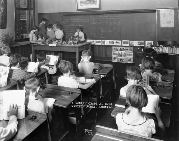 Rear view of a fourth grade class at Washington School, 217 N. Broom Street, at work in the classroom. Caption reads: "A Fourth Grade at Work. Madison Public Schools."