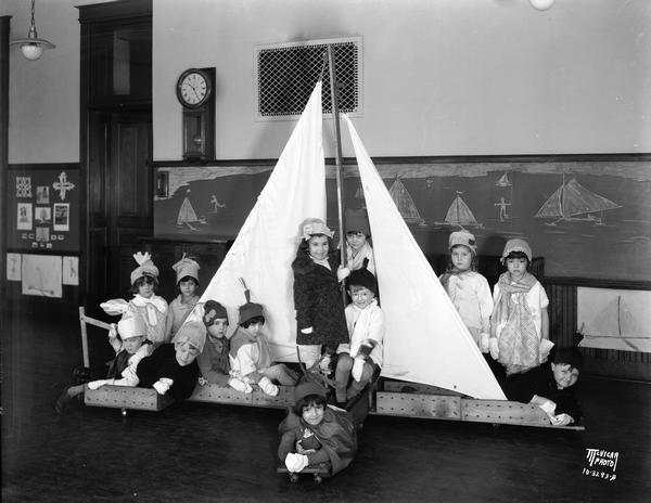 Children in the morning kindergarten class at Draper School, 910 W. Johnson Street,  posing around an iceboat they built. Richard McVicar is sitting to the right of the mast.