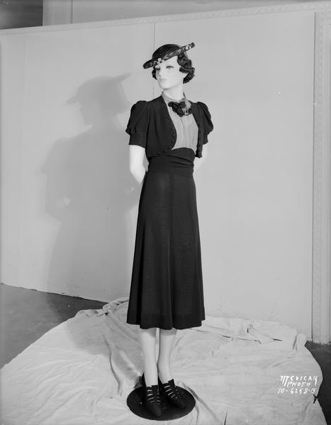 Kessenich's mannequin dressed in jacket dress, hat and shoes.