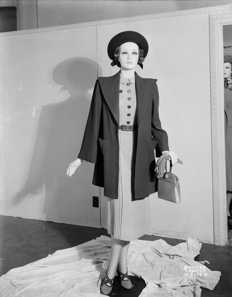 Kessenich's mannequin dressed in dress, coat, hat, purse and gloves and shoes.