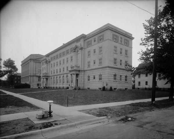 View from street towards the University of Wisconsin-Madison Nurses Dormitory, 1402 University Avenue. There is a water fountain (bubbler) on the sidewalk in the foreground.