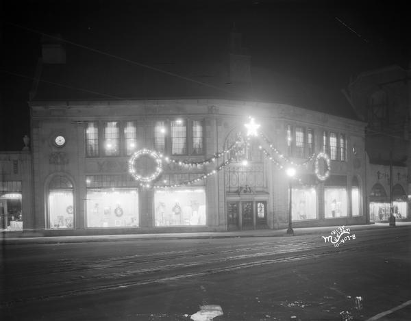Night view of Kessenich's dry goods store building located at 201-203 State Street. Christmas decorations adorn the building.