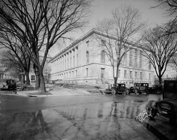 Post Office at 215 Monona Avenue. View looking north from Wilson Street towards the nearly completed front and south sides. The Wisconsin State Capitol is in the background on the left behind trees.