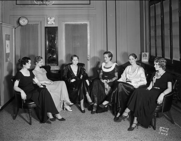 Group portrait of six women sitting in chairs, modeling hair styles at the Cardinal Beauty Shop, 625 State Street.