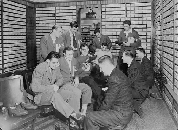 University of Wisconsin athletes trying on shoes in the Walk-Over Shoe Store, 8 East Mifflin Street.