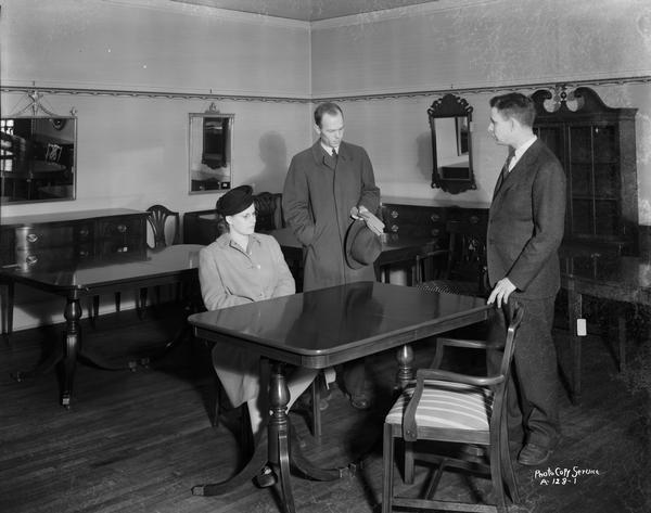 Lowell Frautschi showing a couple a dining room table in the furniture display room at Frautschi's Incorporated, 219 King Street.